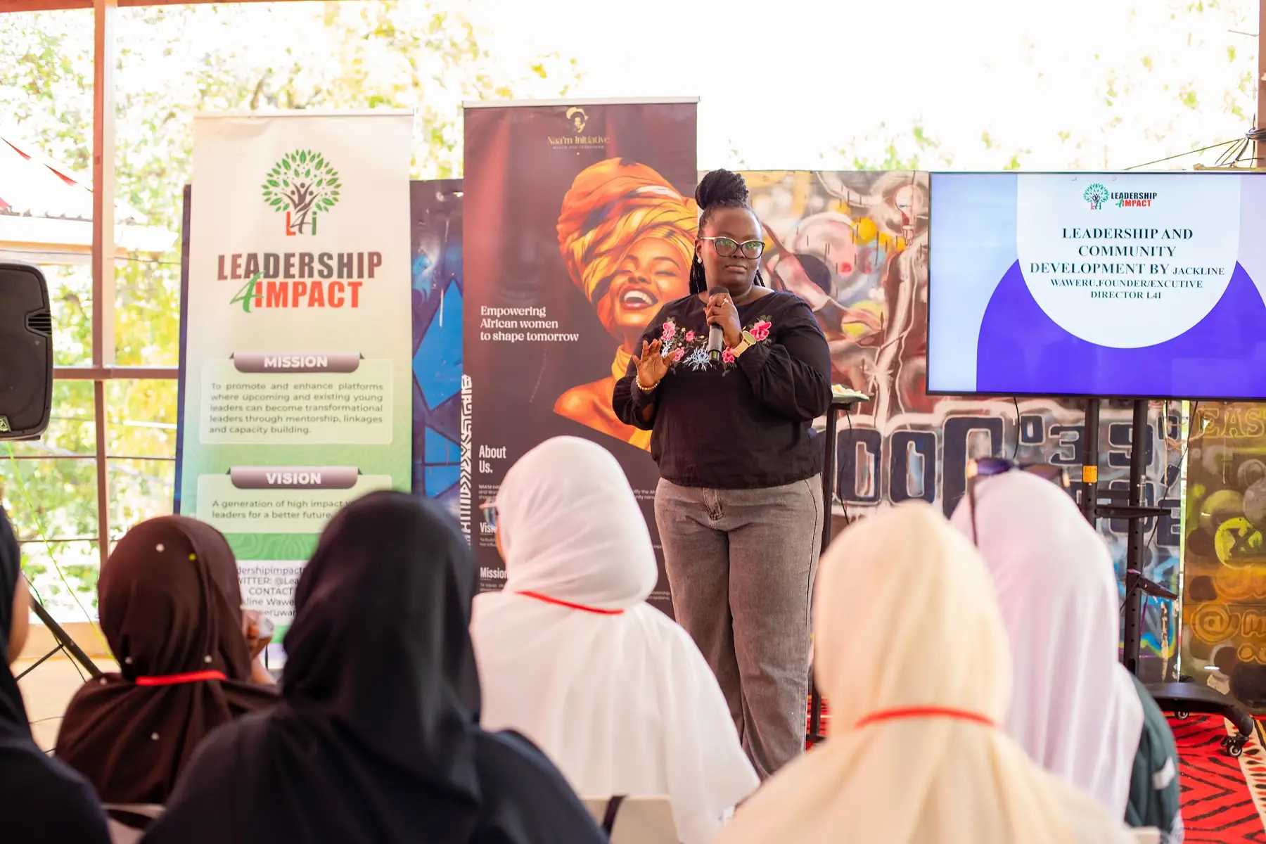 A speaker beside the Leadership and Impact banner